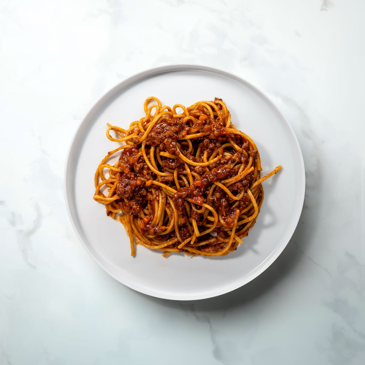 Plate of long pasta with Bolognese Wagyu Nero on marble