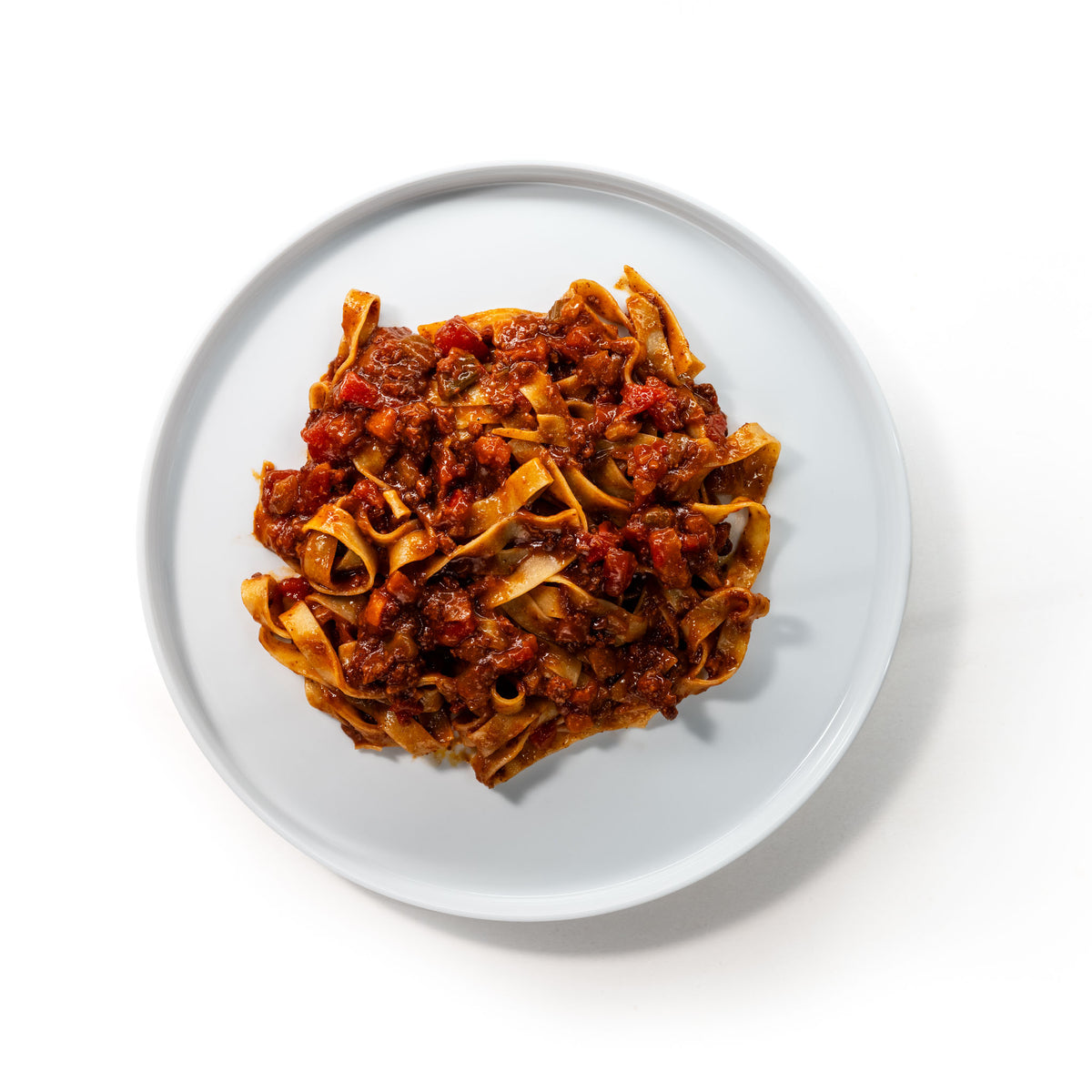Plate of wide ribbon pasta with Bolognese, seen from above