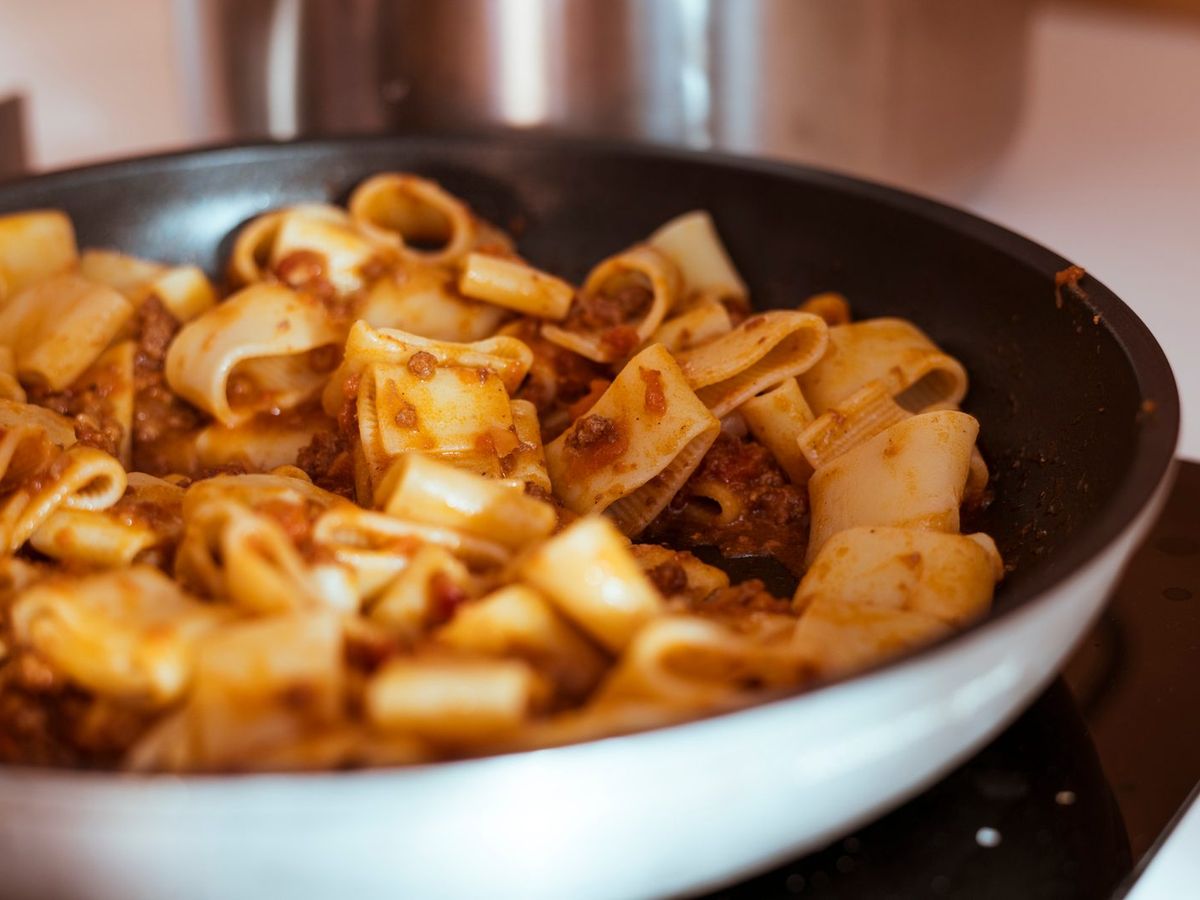 Pasta mit Bolognese in der Pfanne auf dem Herd